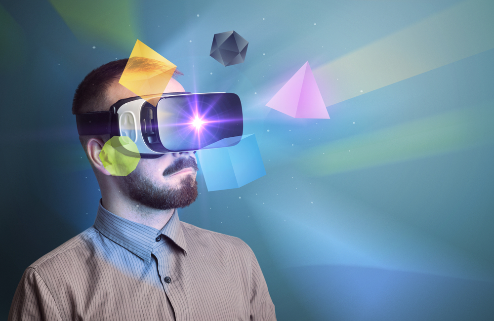 Amazed businessman with virtual reality colorful geometric shapes in front of him