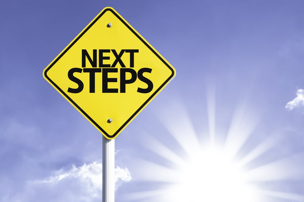 Next Steps road sign with sun background